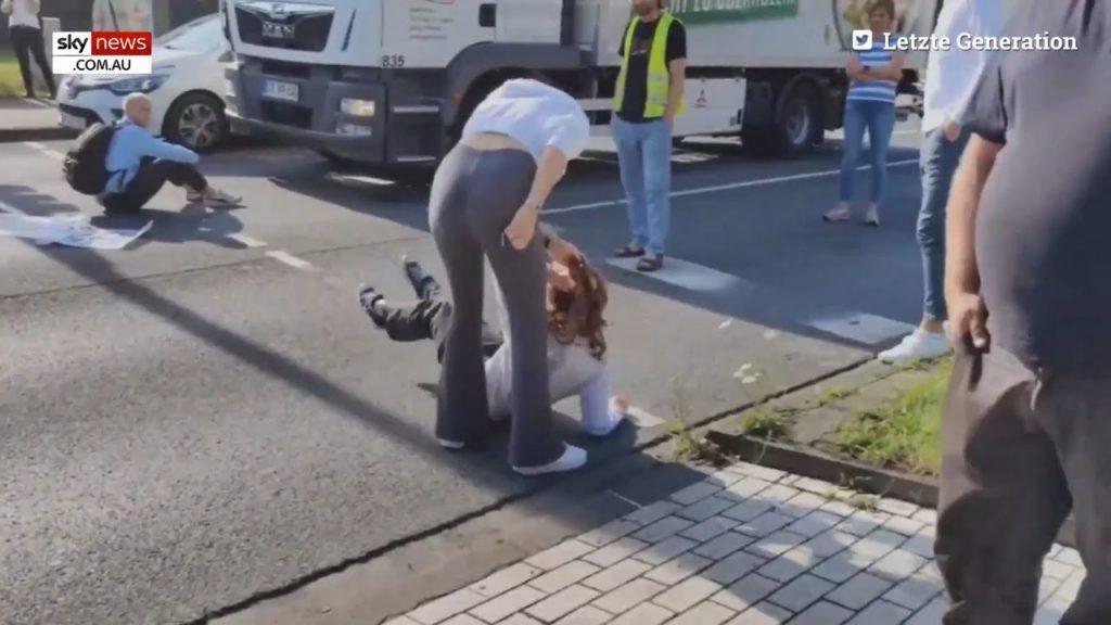 Woman drags climate activist by the hair to stop her from blocking traffic